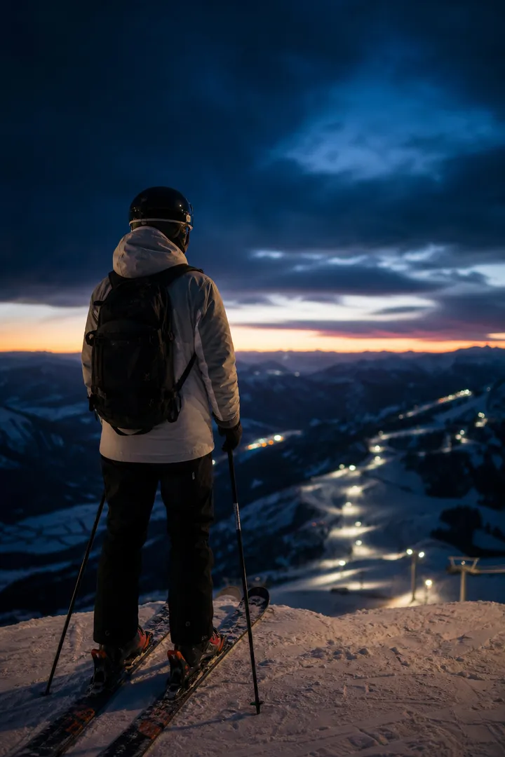 Skifahrer auf einem dunklen Höhenkamm bei Dämmerung