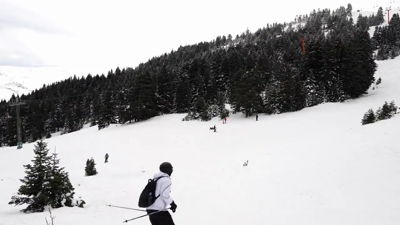 Verschneite Skipiste in den Alpen bei Sonnenschein.